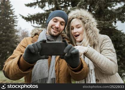 couple winter taking selfie front view