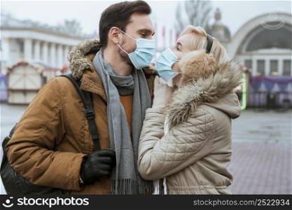 couple winter wearing medical masks hugging
