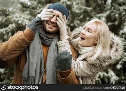 couple winter woman covering her boyfriend face