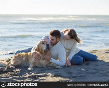 Couple With A Dog enjoying time together On The Beach at autumn day. Couple with dog enjoying time on beach
