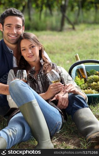 Couple with a glass of wine and basket of grapes