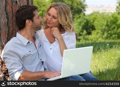 Couple with a laptop outside