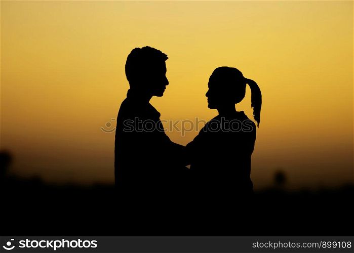 Couple with a silhouette in the park at sky.