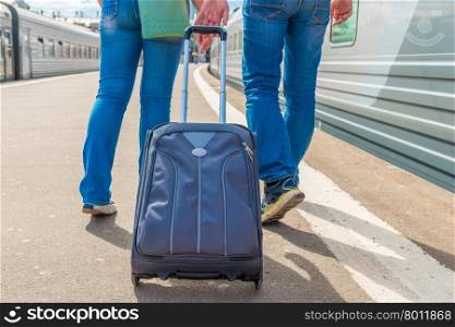 couple with a suitcase embarks on a journey on the train