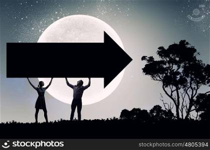 Couple with banner. Silhouettes of young couple holding black arrow banner