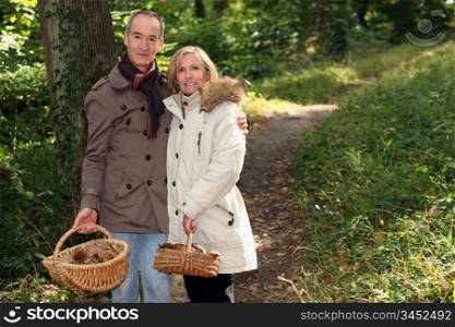 Couple with basket of chestnuts and mushrooms