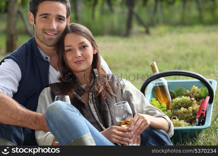 Couple with basket of grapes and wine