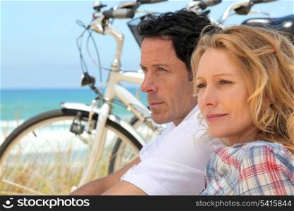 Couple with bicycles by the coast