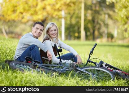 Couple with bicycles resting on the grass