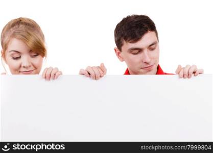 Couple with blank presentation board. Woman and man showing banner sign billboard copy space for text, looking down at it. Advertisement concept.