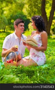 couple with book and apple in park