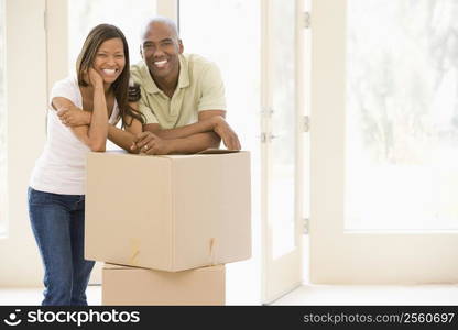 Couple with boxes in new home smiling