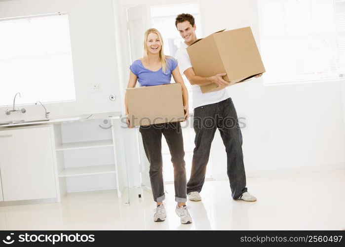 Couple with boxes moving into new home smiling