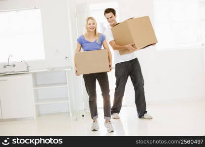 Couple with boxes moving into new home smiling