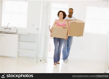 Couple with boxes moving into new home smiling