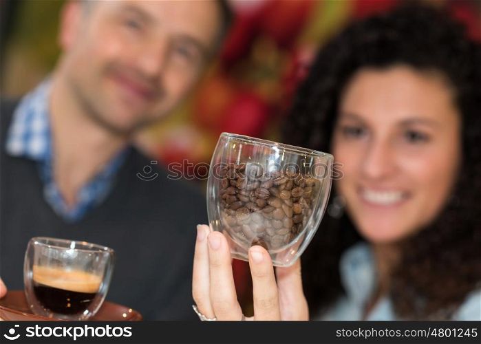 Couple with coffee and beans in glass cups