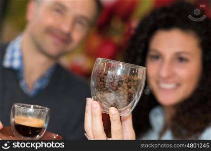 Couple with coffee and beans in glass cups