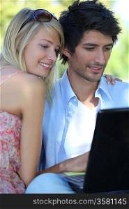 Couple with computer in the garden