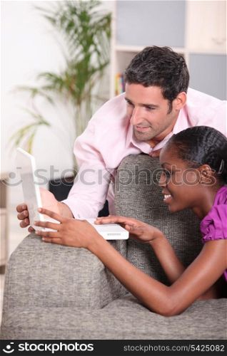 Couple with computer on gray sofa