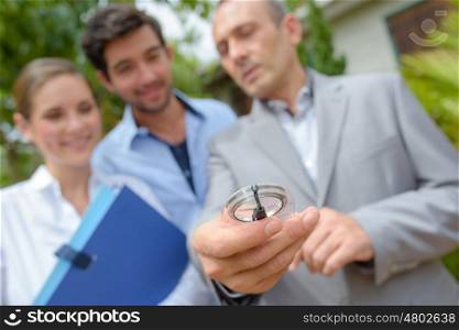 Couple with estate agent holding compass