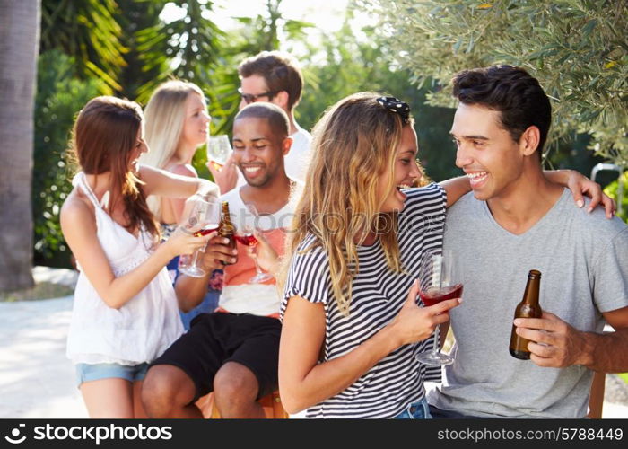 Couple With Friends Drinking Wine And Relaxing Outdoors