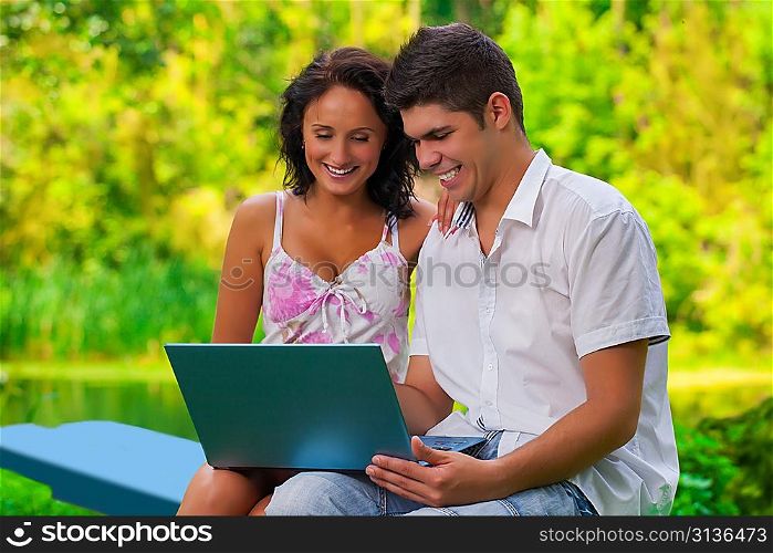 couple with laptop in park
