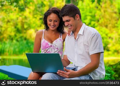 couple with laptop in park
