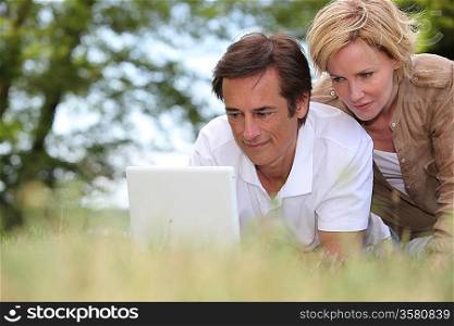 couple with laptop outdoors