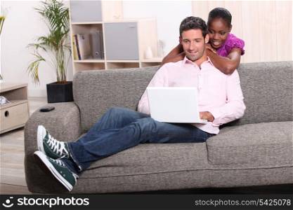 Couple with laptop relaxing at home
