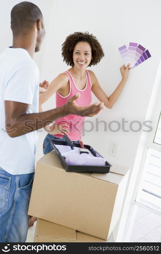 Couple with paint swatches in new home smiling