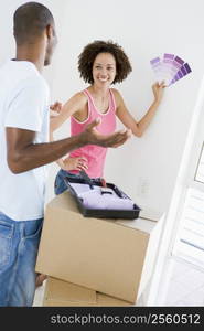 Couple with paint swatches in new home smiling