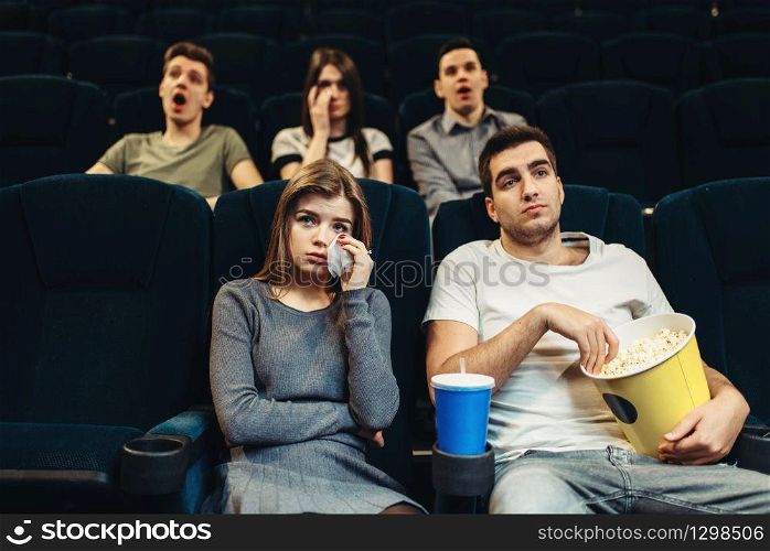 Couple with popcorn in cinema. Boring film concept, people watching movie