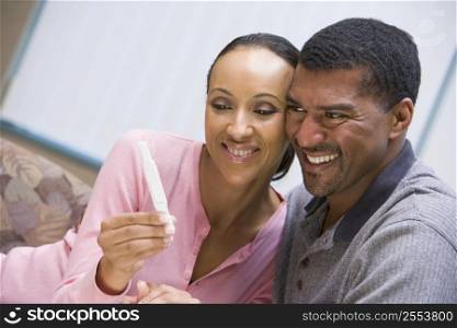 Couple with pregnancy test smiling