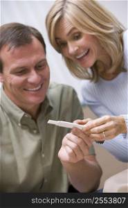 Couple with pregnancy test smiling (selective focus)