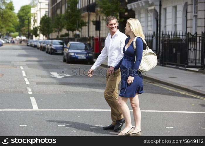 Couple With Pregnant Wife Crossing City Road