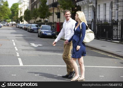 Couple With Pregnant Wife Crossing City Road