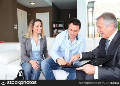 Couple with real-estate agent signing home investment contract