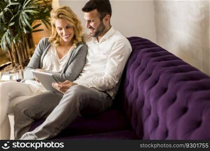 Couple with tablet on sofa