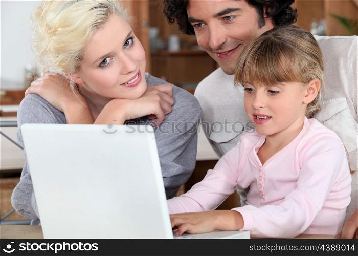 Couple with their daughter and a laptop