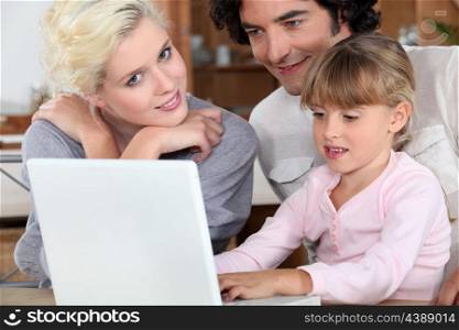 Couple with their daughter and a laptop