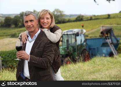 Couple with wine glass in front of vineyard