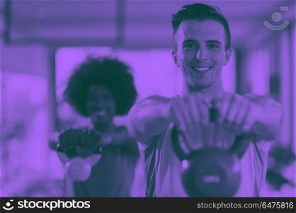 couple workout with weights at crossfit gym. healthy couple workout with weights lifting dumbbels at crossfit gym african american woman with afro hairstyle duo tone filter