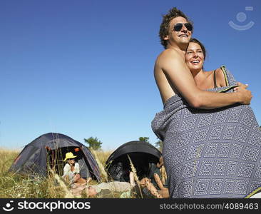 Couple wrapped in a cover at a festival