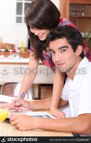 Couple writing on atable