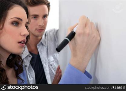 Couple writing on whiteboard