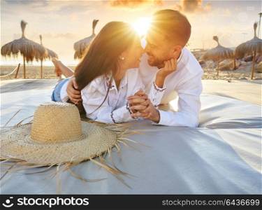 Couple young on beach lounge sunset vacation