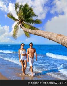 Couple young walking on the beach palm tree in summer vacation