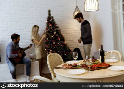 Couples hanging christmas decorations on the tree in the room