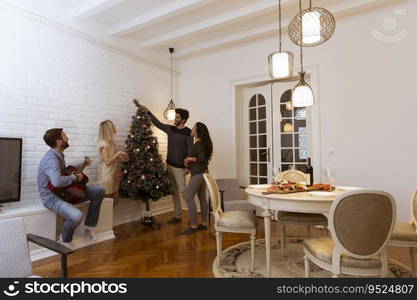 Couples hanging christmas decorations on the tree in the room