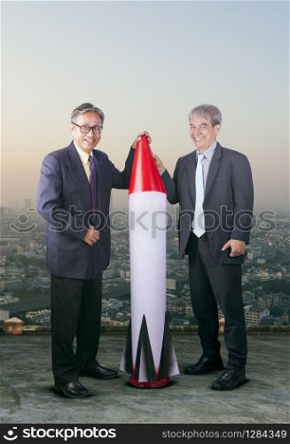couples of asian business man with rocket missile ,conceptual for business strategy target,and crazy warrior